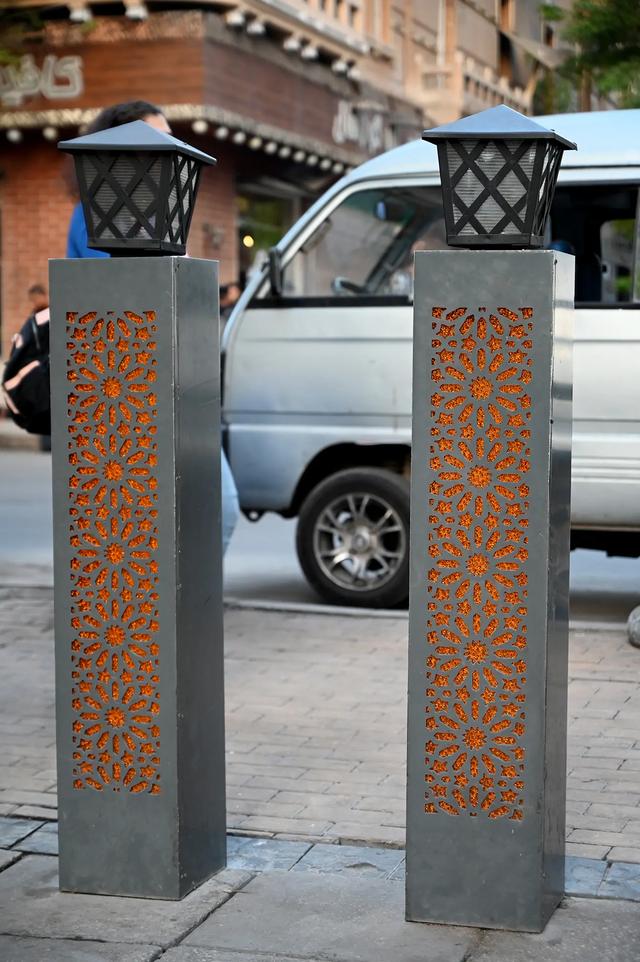 Lampposts between the pedestrian section and the second part of the street.